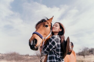 Young happy woman with her horse in evening sunset light. Outdoor photography with fashion model girl. Lifestyle mood. oncept of outdoor riding, sports and recreation. - obrazy, fototapety, plakaty