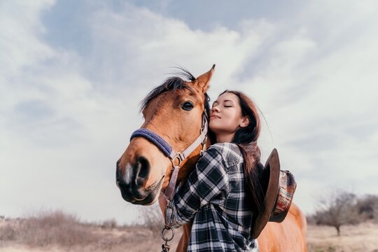 Young happy woman with her horse in evening sunset light. Outdoor photography with fashion model girl. Lifestyle mood. oncept of outdoor riding, sports and recreation.