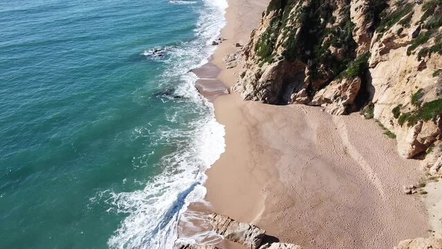 Aerial drone view of a deserted beach with many waves on the Costa Brava, Catalonia, Spain.