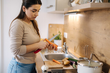 Young mom preparing food at home for her family. Caring woman prepares homemade food
