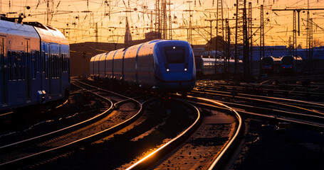 Express and local trains arriving at Dortmund main station in warm evening light. Curved main line...