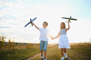 Active running kids with boy holding airplane toy.