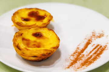 Pastéis de nata, Pastel de nata. Portuguese egg custard tart pastry, fresh from oven, served with cinnamon. Famous dessert in Portugal. Selective focus and copy space.
