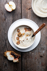 Two bowls of homemade Jerusalem artichoke and apple cream soup and open sandwich with homemade pate with fresh apple and cherry jam on wooden table.
