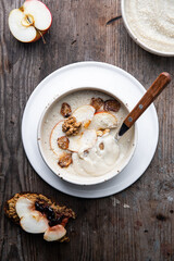 Two bowls of homemade Jerusalem artichoke and apple cream soup and open sandwich with homemade pate with fresh apple and cherry jam on wooden table.