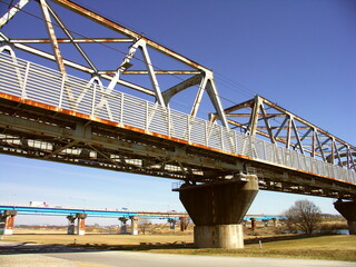 早春の江戸川に架かる老朽化した武蔵野線鉄橋と流山橋