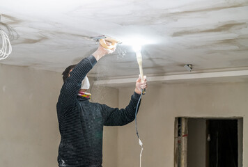 hand sanding of the plasterboard ceiling with a trowel