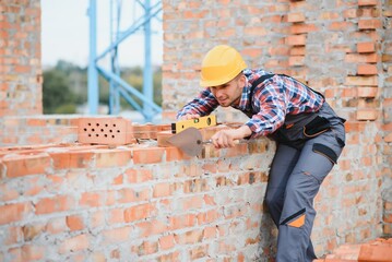 Construction worker in uniform and safety equipment have job on building. Industrial theme