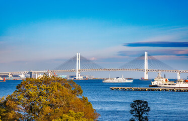 横浜港にかかる大きな橋と海を航行する遊覧船