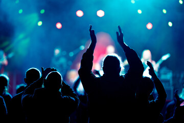 Audience and fans enjoy live music on a concert with blurry bokeh background - obrazy, fototapety, plakaty