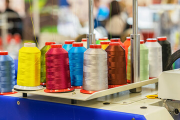 Many spools of multicolored threads for embroidery production machine, textile industry, industrial...
