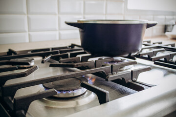 hornalla de gas en cocina de familia argentina, preparando la comida, en el dia del gas natural argentino. colores calidos del fuego y fondo en contraste blanco.