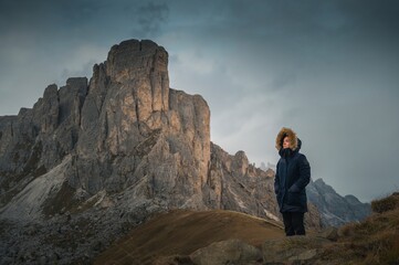 Woman enjoying the top of the mountain, overlooking a snowy range, Dolomites Italy