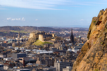 Edinburgh castle bathed in spring sun with Salisbury Crags on right - obrazy, fototapety, plakaty
