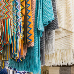 Fototapeta na wymiar Several of warm rugs, stoles closeup. Accessories for cold weather from natural material
