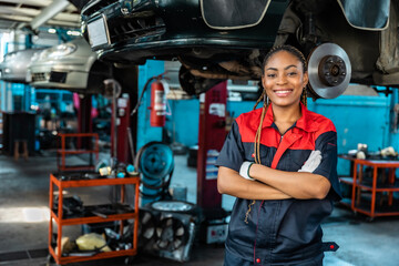 Engineer team checking under car condition on lifter in garage.Young auto mechanic in uniform is...