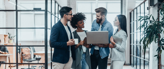 Group of confident business people discussing business while working in the office together