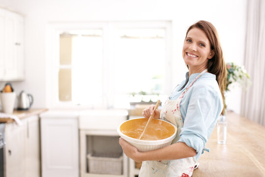 Perfecting her baking skills. A mature woman smiling as she bakes in the kitchen.