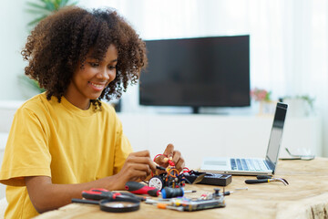 Happy cheerful American - African black ethnicity female university student learning about robotic and programing.