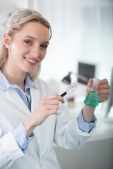 female scientist looking at test tube