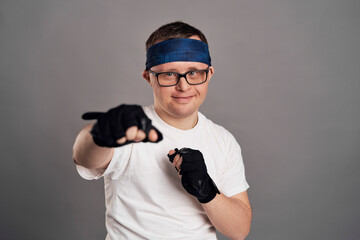 Man with down syndrome boxing on gray background