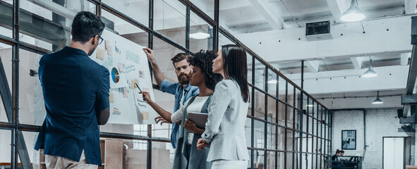 Confident business team examining graphs while working together in the office