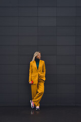 Beautiful happy woman posing at gray city wall background, enjoy life concept