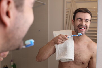 Shirtless man washing his teeth 