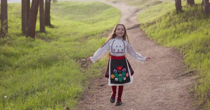 Bulgarian girl in traditional folklore costume running in forest of majestic mountain, 4k slow motion video. Bulgaria,Rhodope nature