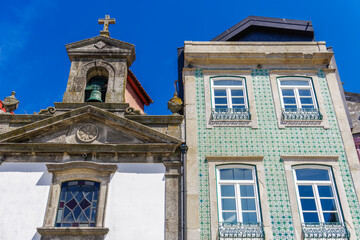 Fototapeta na wymiar Porto, Portugal Ribeira church next to a house. Day view of facade with house with traditional Portuguese Azulejo tiles.