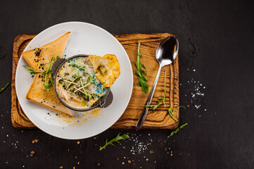 Fresh onion cream soup and crottons on wooden background