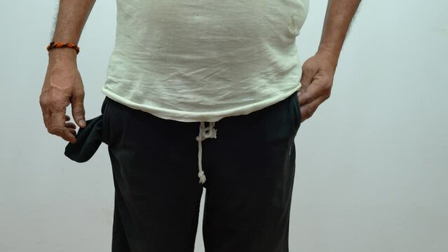 A poor man showing his empty pocket with no money, jobless man with no saving and income concept
