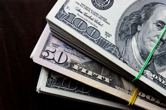 Three stacks of dollars. A lot of 100 and 50 dollars bills, close up. Financial business concept.