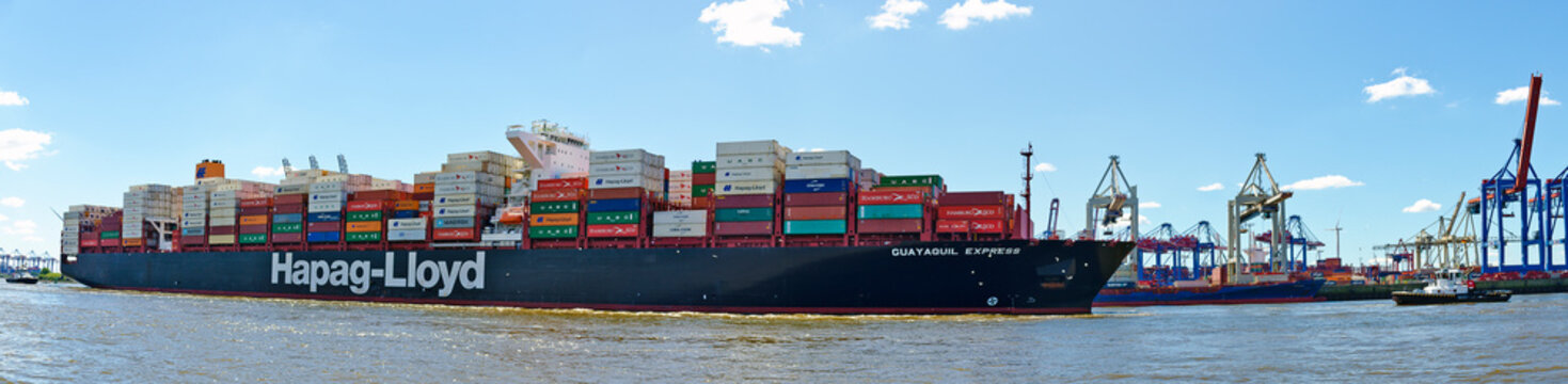 Very large container ship with tug boats on the river Elbe leaving the port of Hamburg, Germany
