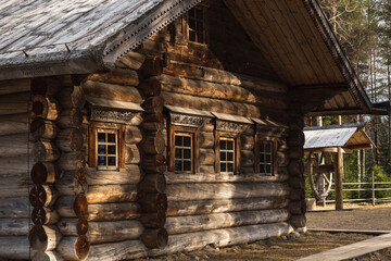 Traditional Russian wooden countryside house (izba), with decorative carved window shutters. Russian North