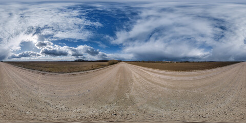 spherical 360 hdri panorama on gravel road with clouds on blue sky in equirectangular seamless projection, use as sky replacement in drone panoramas, game development as sky dome or VR content