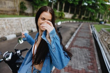 Portrait of a woman brunette smile with teeth walking outside against a backdrop of palm trees in the tropics, summer vacations and outdoor recreation, the carefree lifestyle of a freelance student.