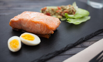 baked salmon fillet with homemade guacamole and quail eggs halves