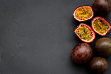 Whole and half of fresh passion fruit with leaf, top view