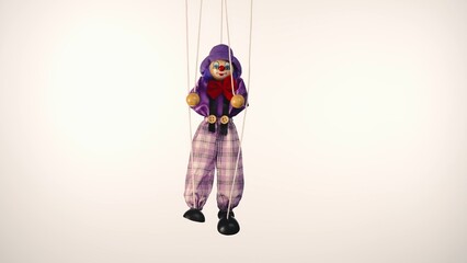 Marionette clown hanging on strings. A rag doll in a purple suit and hat, with a red bow, nose and makeup. Soft doll harlequin funster on a white studio background. Close up.