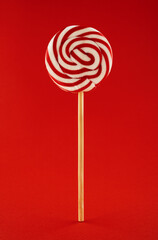 Sweet lollipop red colors isolated on red background. Spiral red and white lollypop.