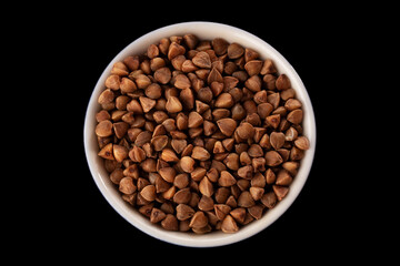 Buckwheat groats on a black background. Macro. Close-up