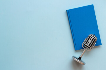Fototapeta na wymiar Recording audiobook or podcast with microphone and book, top view