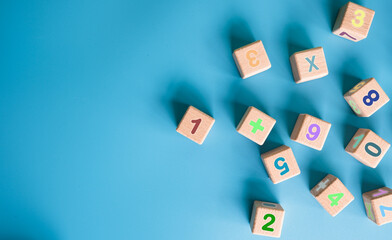 Colorful wooden cubes with numbers scattered on blue background. learning, increasing IQ, development for children. Top view of children's toys. Educational games.