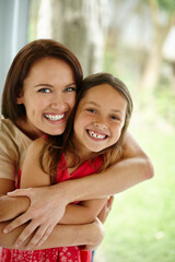She cherishes her little girl. Portrait of a mother embracing her daughter at home.