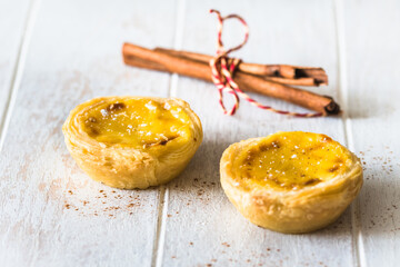 Traditional portuguese dessert, pastel de nata, pasteis de nata, egg tart, on white wooden background