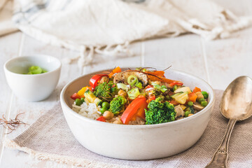 Bowl with rice and vegetables on white wooden table, vegetarian, vegan, healthy food