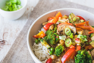 Bowl with rice and vegetables on white wooden table, vegetarian, vegan, healthy food