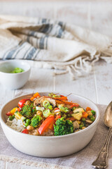 Bowl with rice and vegetables on white wooden table, vegetarian, vegan, healthy food