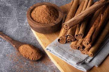 Cinnamon sticks on a wooden background. Cinnamon spice in a spoon and bowl. Ceylon cinnamon. Cinnamon powder.